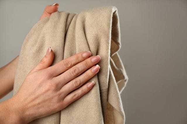 Woman Holding a Cashmere Sweater