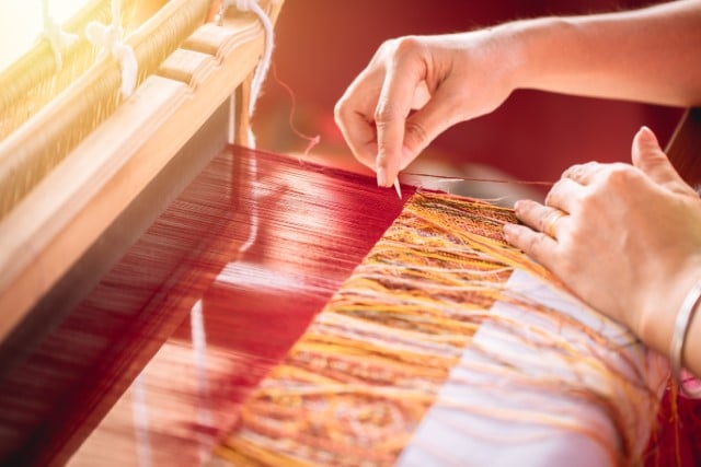 A Tapestry Needle Being Used by a Weaver on a Loom